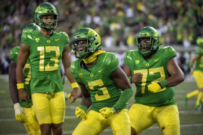 Oregon wide receiver Traeshon Holden, center, celebrates a touchdown against Hawaii with quarterback Ty Thompson, left, and offensive lineman Iapani Laloulu during the second half Saturday in Eugene. (Andy Nelson / ASSOCIATED PRESS)