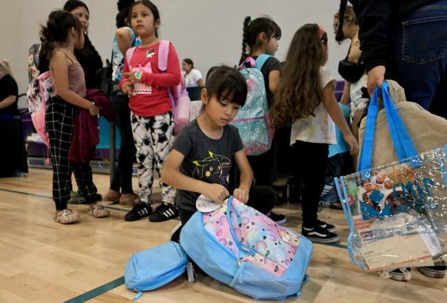 Layla Islas gets down to business as she checks out a backpack she received at Boys and Girls Club of Roseland, Saturday, Aug. 5, 2023.  (Kent Porter / The Press Democrat) 2023