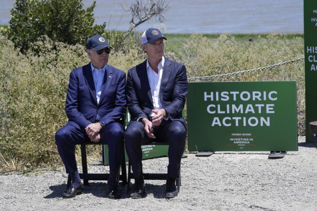 FILE – President Joe Biden sits with California Gov. Gavin Newsom while they listen to speakers at the Lucy Evans Baylands Nature Interpretive Center and Preserve in Palo Alto, California, on Monday, June 19, 2023. Newsom has pursued an aggressive climate policy as governor, including committing to spend tens of billions of dollars over the next few years on enviro<em></em>nmental projects and programs. But his proposals have been met with criticism by some enviro<em></em>nmental groups, who say they don't do enough to protect the state's threatened species and fragile ecosystems. (AP Photo/Susan Walsh, File)