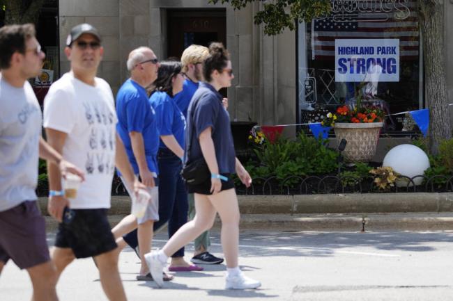 People participate in a community walk in Highland Park, Ill., Tuesday, July 4, 2023. One year after a shooter took seven lives at the city's annual parade, community members are planning to ho<em></em>nor the victims and reclaim the space to move forward. (AP Photo/Nam Y. Huh)