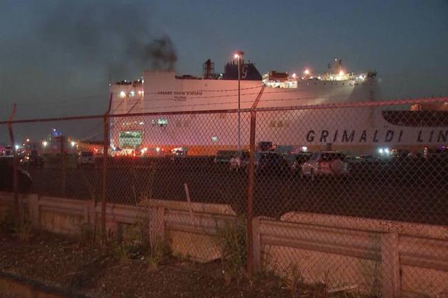 In this image taken from video, smoke rises from a cargo ship early Thursday, July 6, 2023, in the port of Newark, New Jersey. Two firefighters were killed battling the blaze that began when cars caught fire deep inside the ship carrying 5,000 cars at the port, Newark's fire chief said. (WABC-TV via AP)