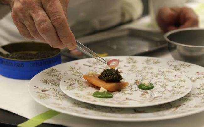 In this photo taken Thursday, March 9, 2017, chef Thomas Keller puts the finishing touch to a caviar dish in the new kitchen at the French Laundry restaurant in Yountville. (AP Photo/Eric Risberg)