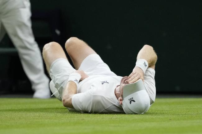 Britain’s Andy Murray reacts after slipping and falling trying to play a shot to Stefanos Tsitsipas of Greece during Thursday’s match at Wimbledon in London. (Kirsty Wigglesworth / ASSOCIATED PRESS)